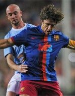 Il capitano Puyol contrastato da un calciatore del City