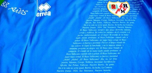 Terza maglia del Rayo con l'inno del club che forma la banda diagonale Dettaglio terza maglia Rayo Vallecano 2012-2013