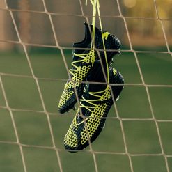 Le scarpe Puma future appese alla rete da calcio